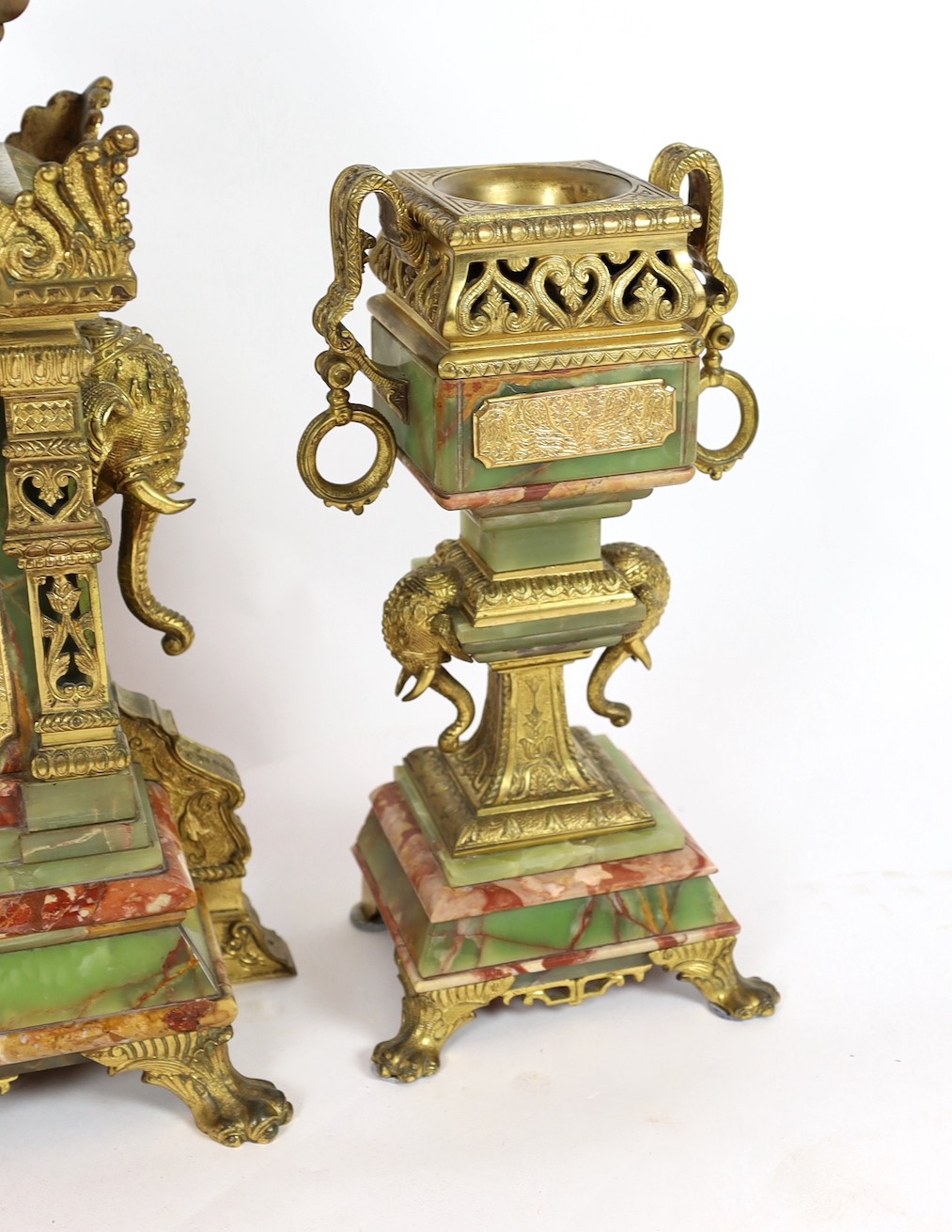 A late 19th century French ormolu mounted marble and green onyx clock garniture, of Indian inspiration, clock 34cm wide, 63cm high, side vases 36cm high